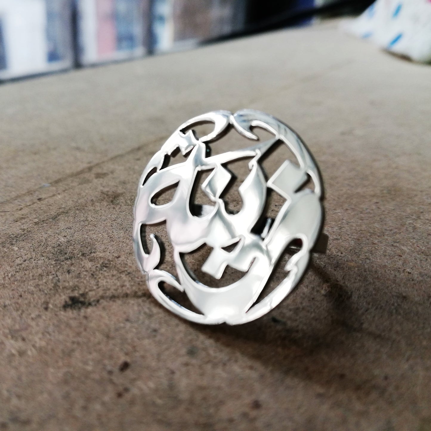 A silver arabic calligraphy custom name ring with an intricate openwork design,