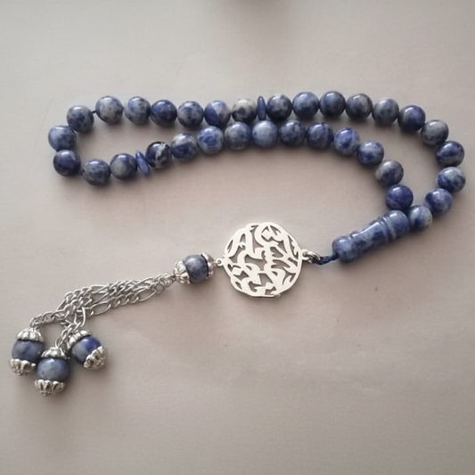 Blue beaded necklace with a silver clasp on a light gray background