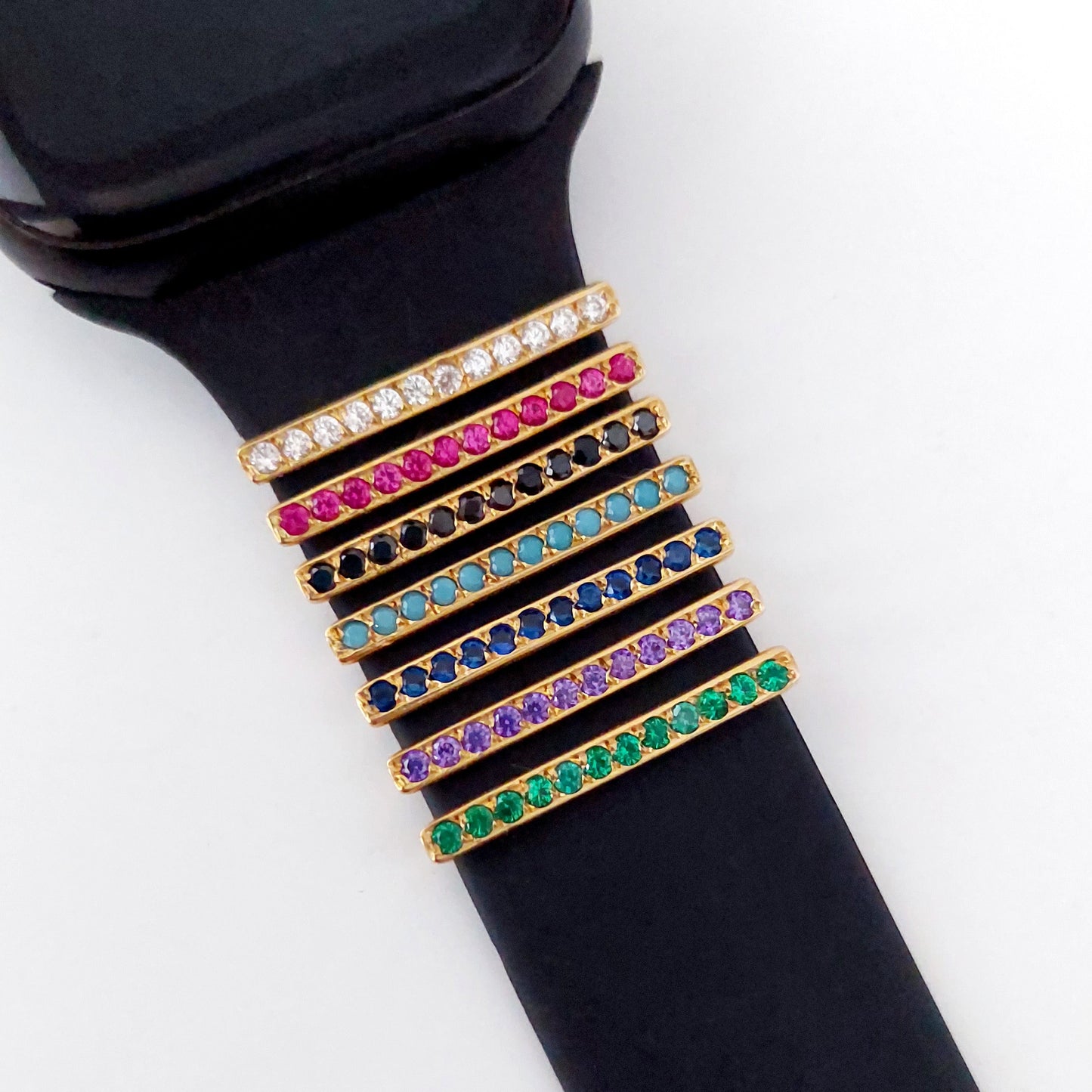 Black smartwatch with a colorful gemstone band on a white background