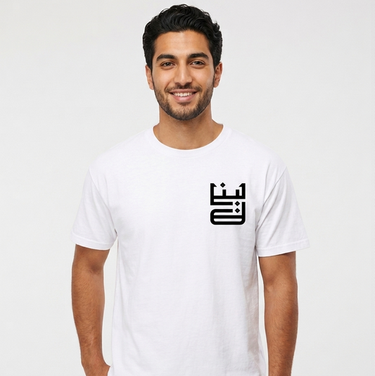 Man wearing a white t-shirt with a black logo on a plain background with lebanon on the shirt in arabic