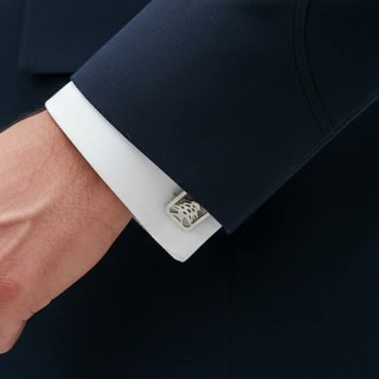 a man wearing a suit and showcasing his cedar silver cufflinks