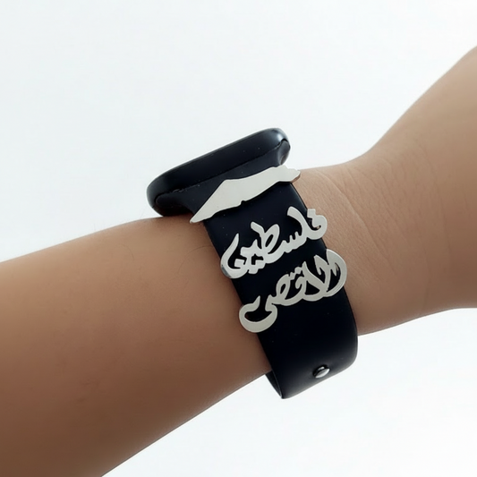 Black wristband with silver palestine map on a wrist against a white background
