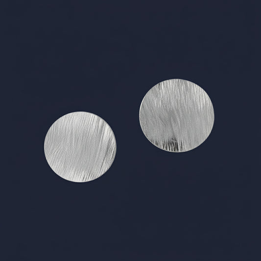 Silver earrings on a blue background
