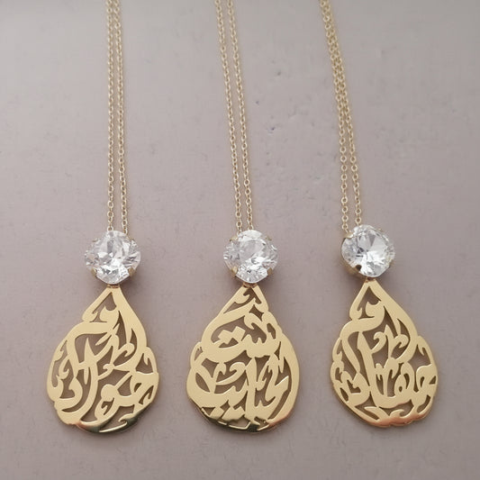 Three gold necklaces with teardrop pendants and crystal beads on a gray background with 'Demirel' branding.