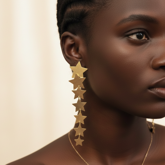 Woman wearing gold star earrings against a beige background