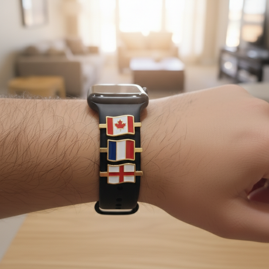 Wrist wearing a watch with a band featuring multiple flags in a blurred indoor setting, canada france and england flags