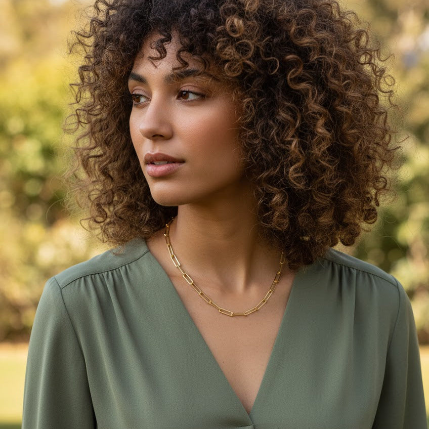 Woman wearing a green top with a blurred natural background