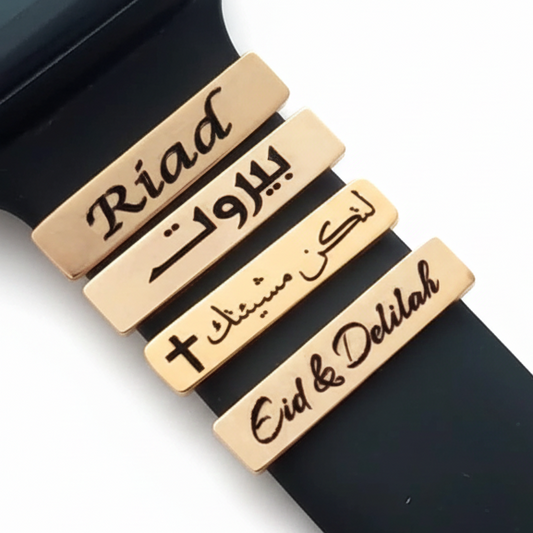 Black smart watch band with gold nameplates on a white background