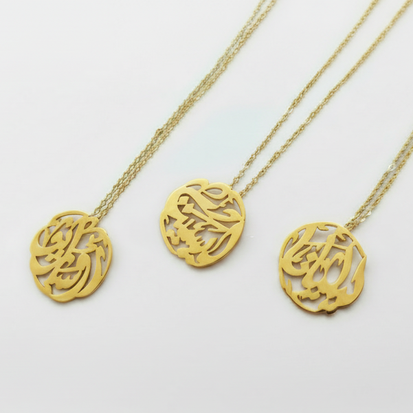 Three gold necklaces with arabic calligraphy pendants on a white background