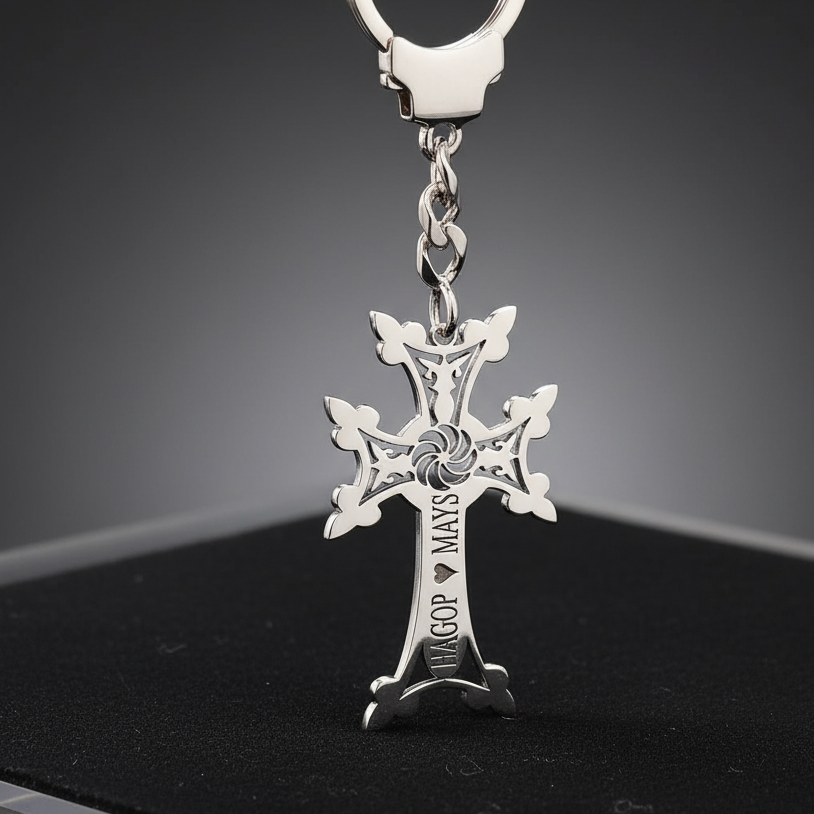 armenian khachkar keychain with names on a dark surface