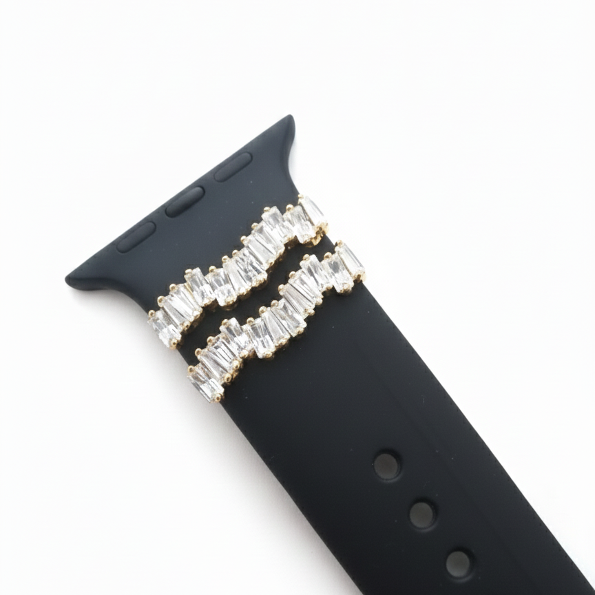 Black watch strap with gold charm with baguette stones on a white background