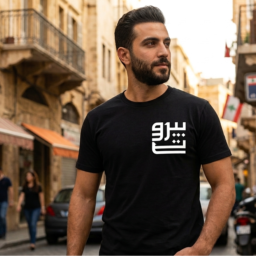 Man wearing a black t-shirt with a beirut logo on a street in an urban setting