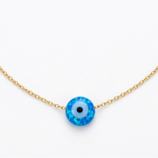 Gold bracelet with a blue evil eye charm on a white background