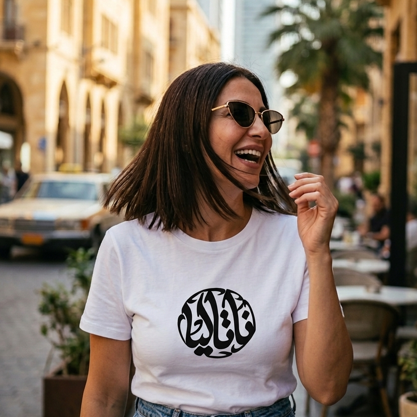 Woman wearing a white t-shirt with Arabic text on a city street
