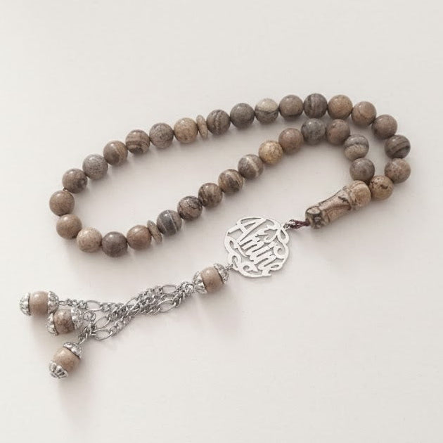 Necklace with brown jasper beads and silver clasp on a white background