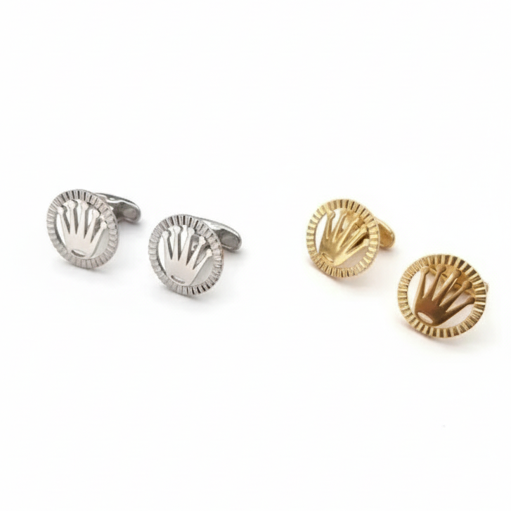 a display of two cufflinks, framed rolex logo in gold and silver