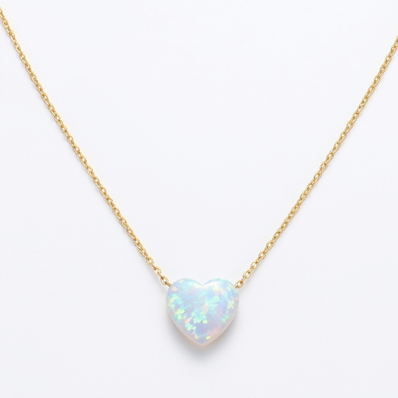 Gold necklace with a heart-shaped opal pendant on a white background