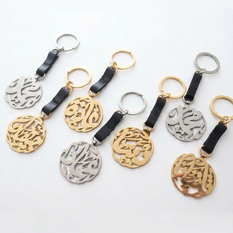 a set of 7 keychains with arabic calligraphy in gold and silver finish with leather