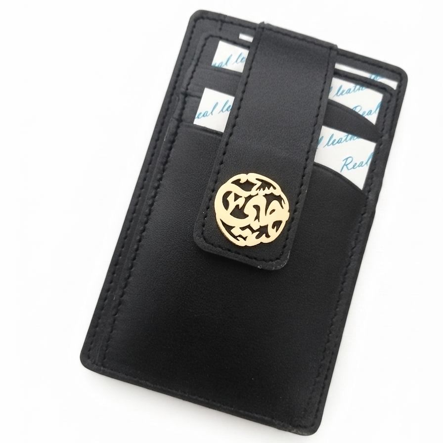 A black leather card holder wallet with a gold circular arabic calligraphy name, shown on a plain white background.