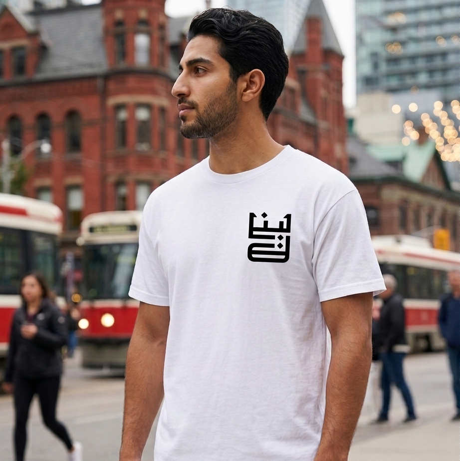 Man wearing a white t-shirt with a black logo in an urban setting with lebanon script written on the shirt