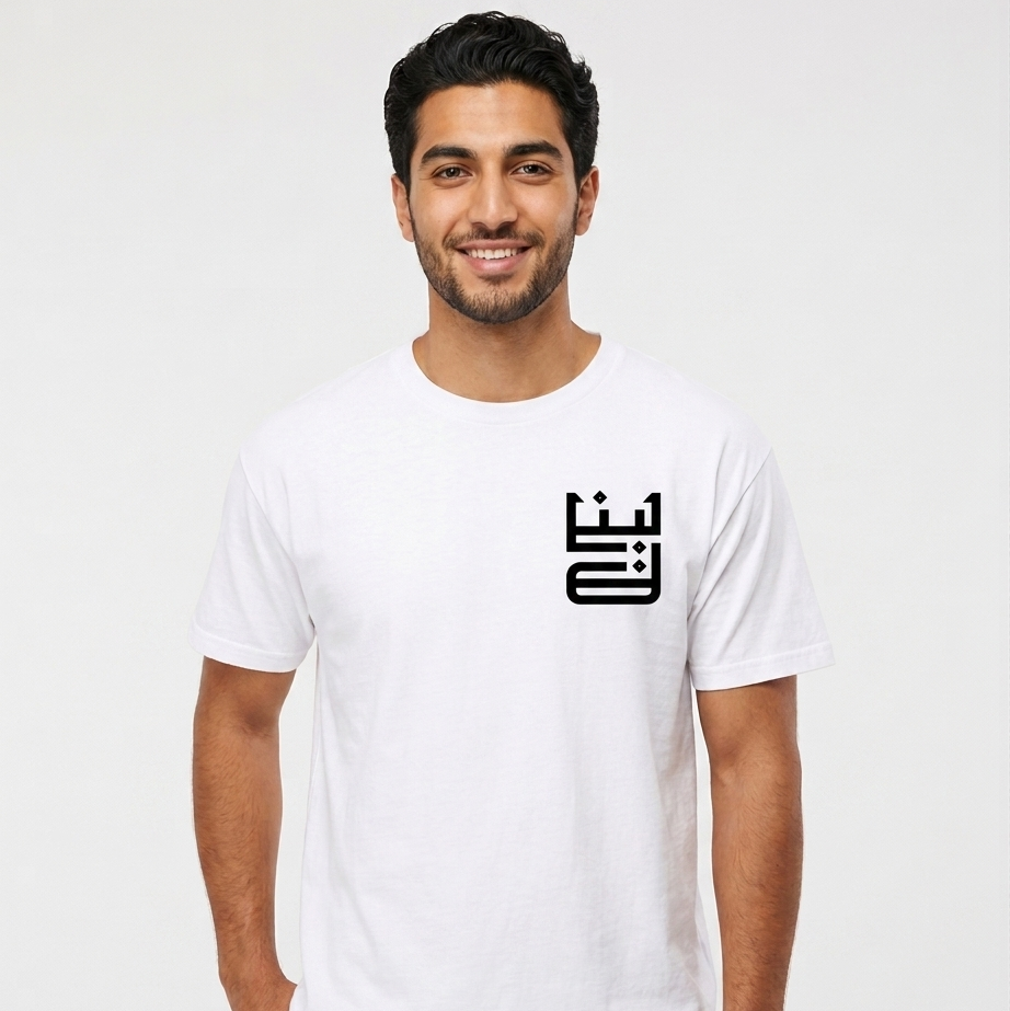 Man wearing a white t-shirt with a black logo on a plain background with lebanon on the shirt in arabic