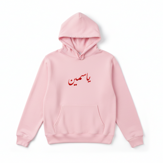 light pink hoodie on a white background with an arabic name calligraphy in red