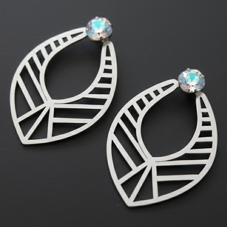 Pair of geometric hoop earrings with gemstones on a black background