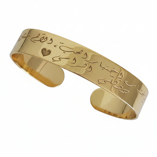 Gold bracelet with intricate designs on a white background