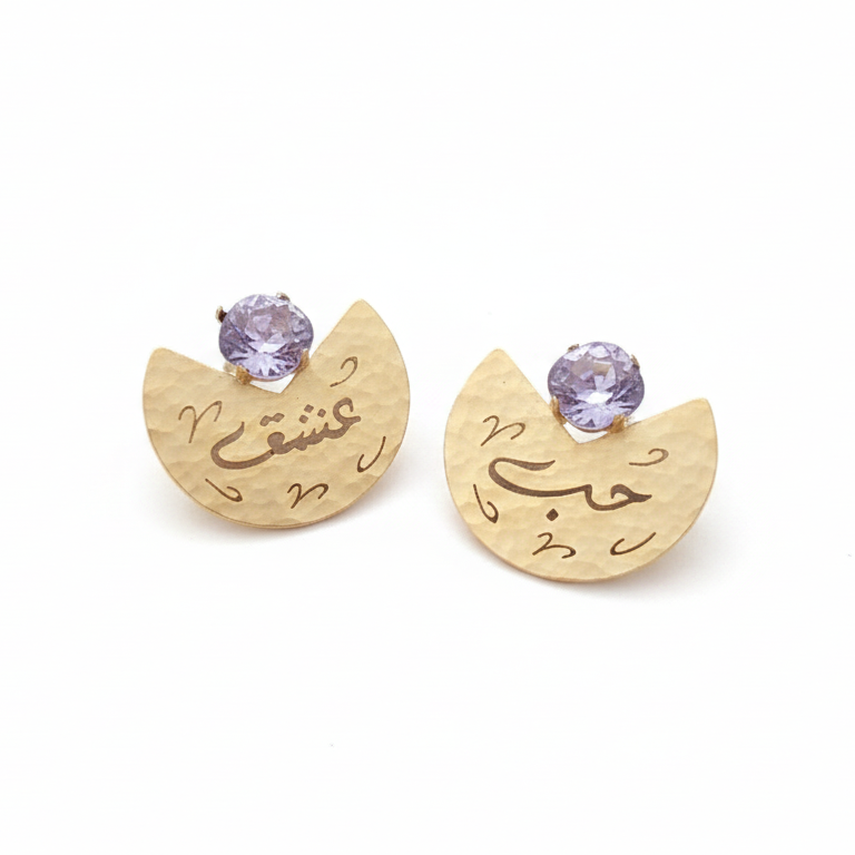 Gold earrings with purple stones on a white background