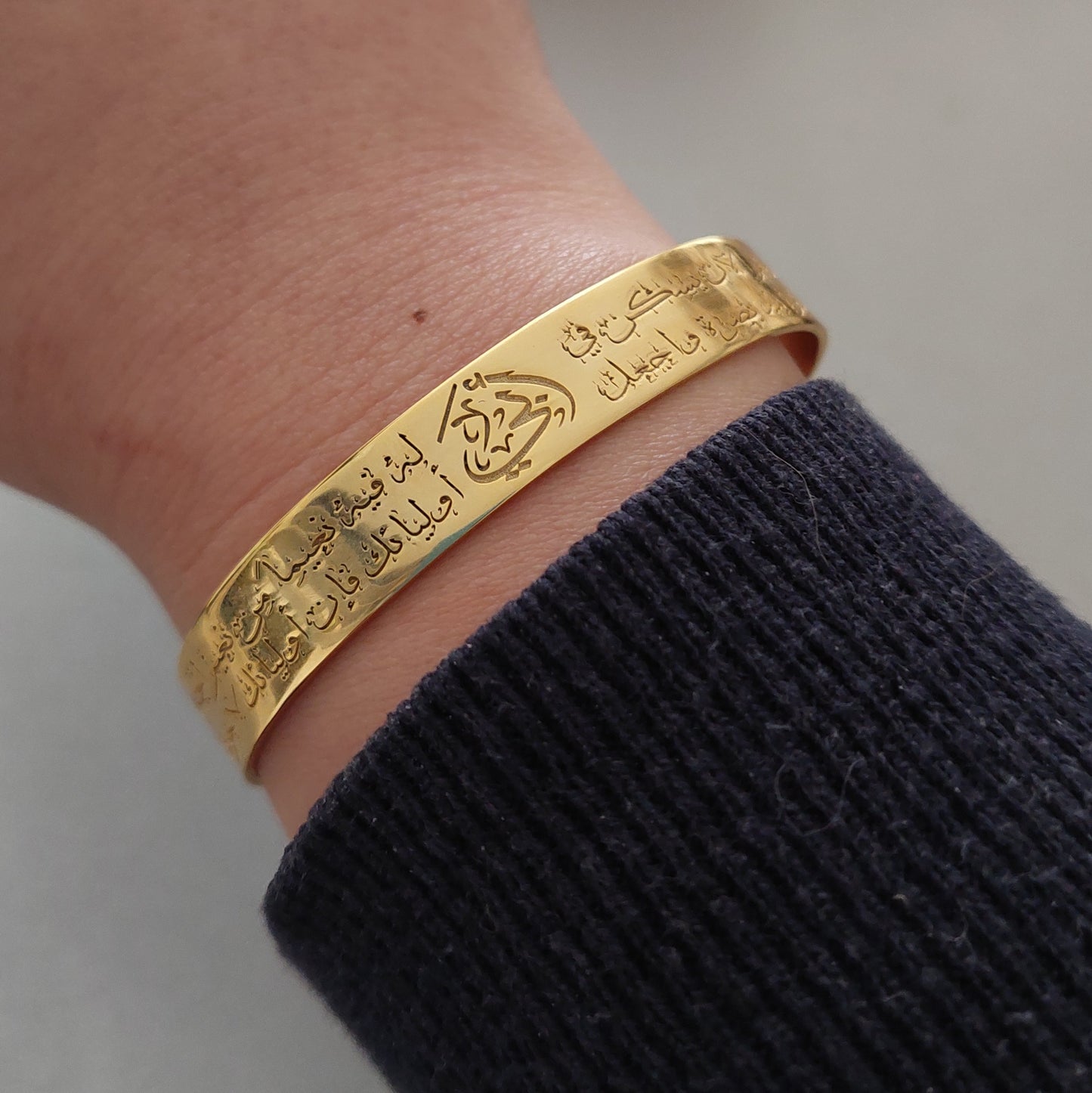 a womans hand with a close up personalized gold bracelet