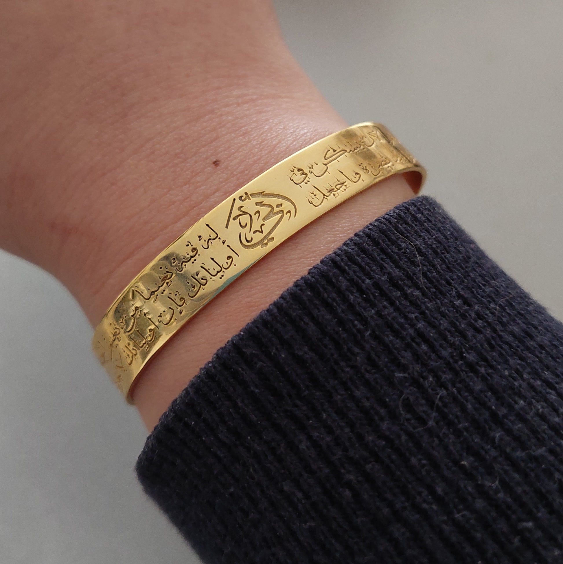 a womans hand with a close up personalized gold bracelet