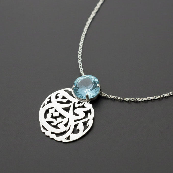 Necklace with a silver pendant and blue gemstone on a dark background