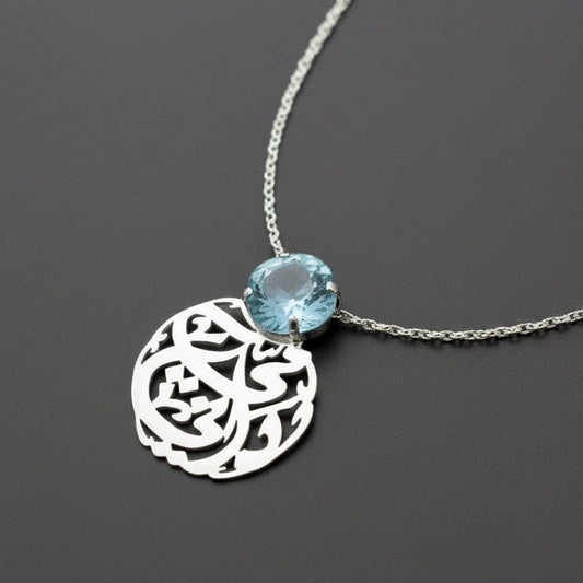 Necklace with a silver pendant and blue gemstone on a dark background