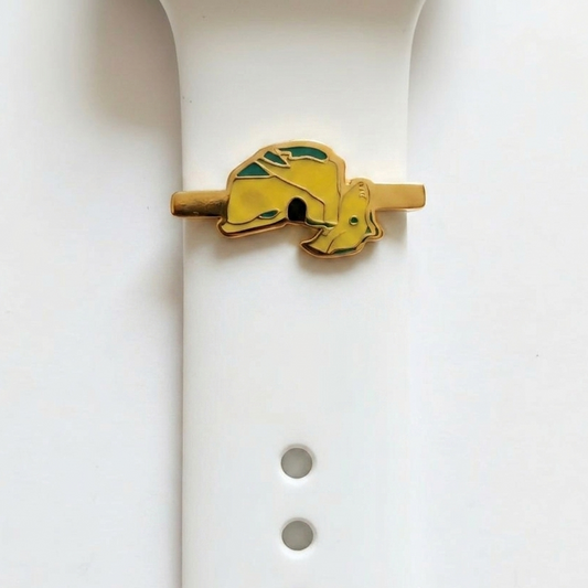 Yellow and gold raouche shaped watch charm on a white watch rubber band on a white background
