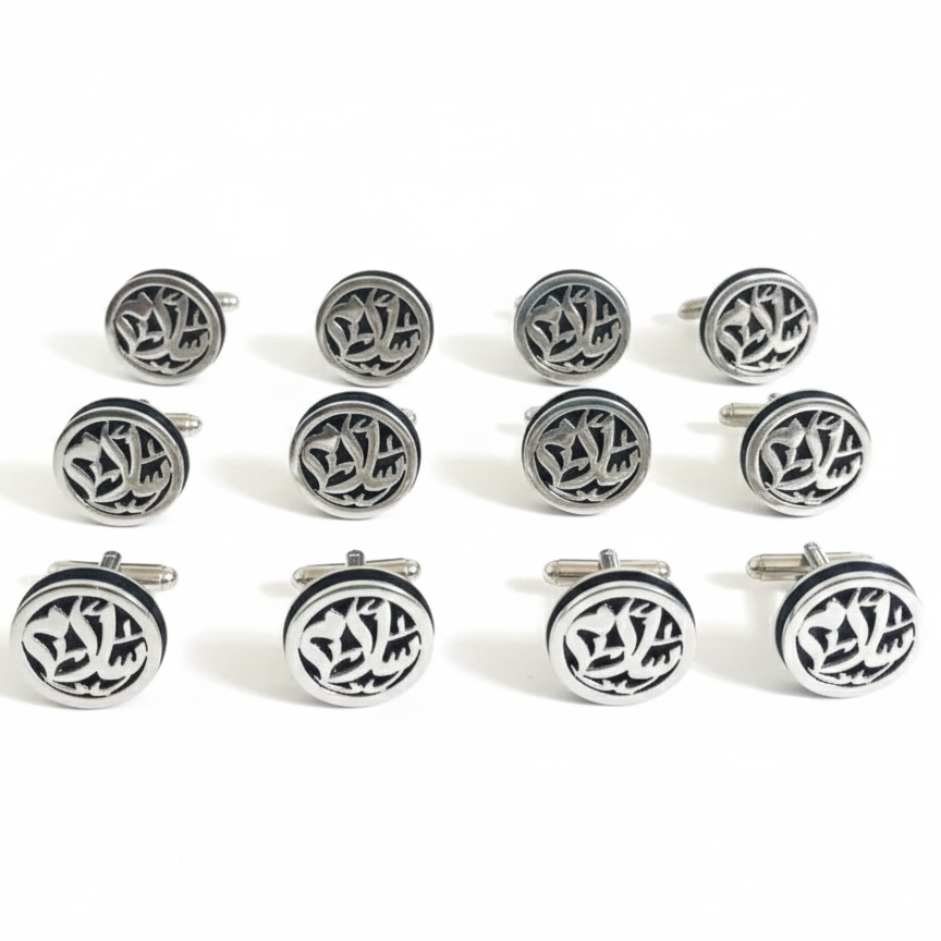 Set of silver cufflinks with intricate designs on a white background