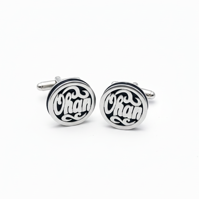 Pair of silver cufflinks with name Ohan engraving on a white background