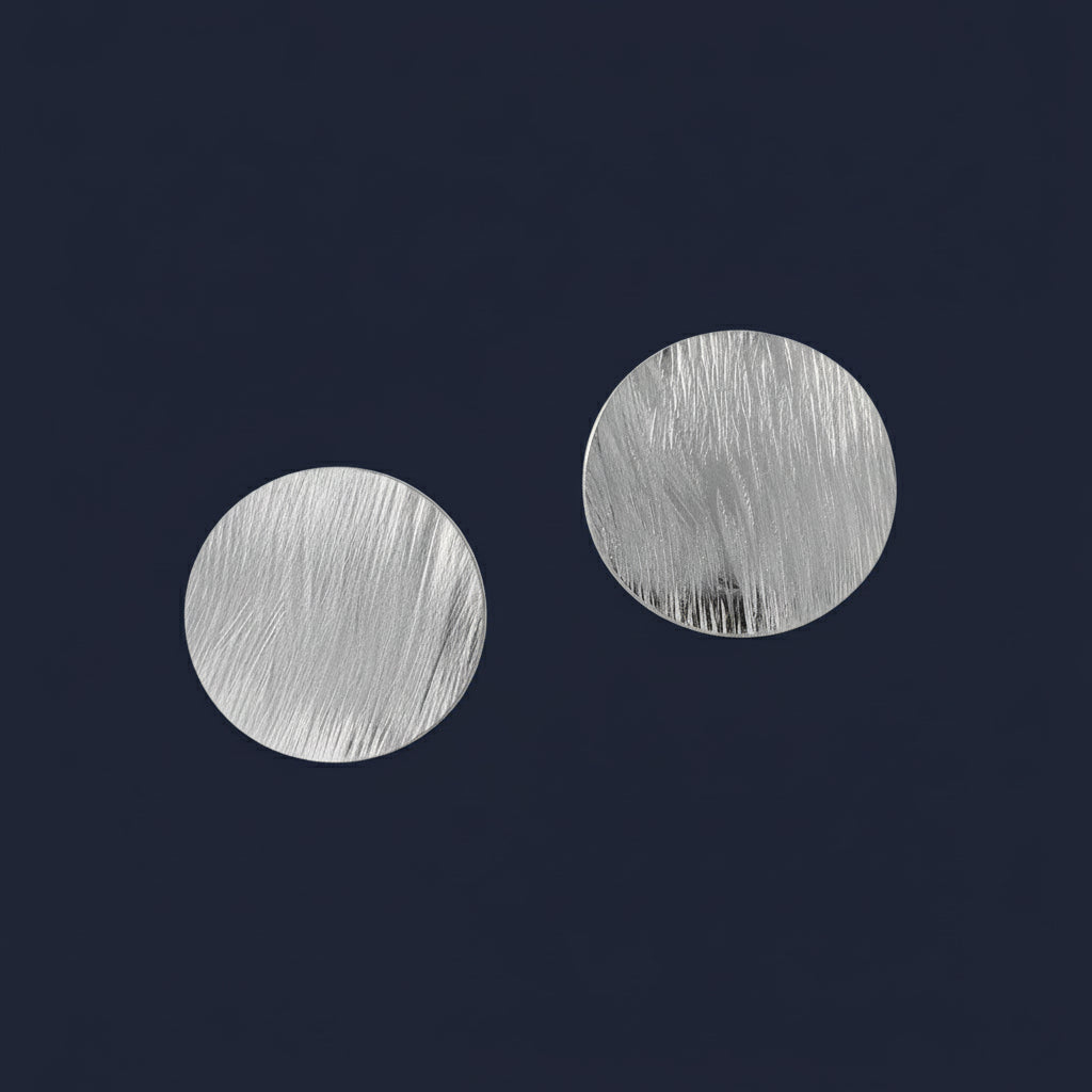 Silver earrings on a blue background