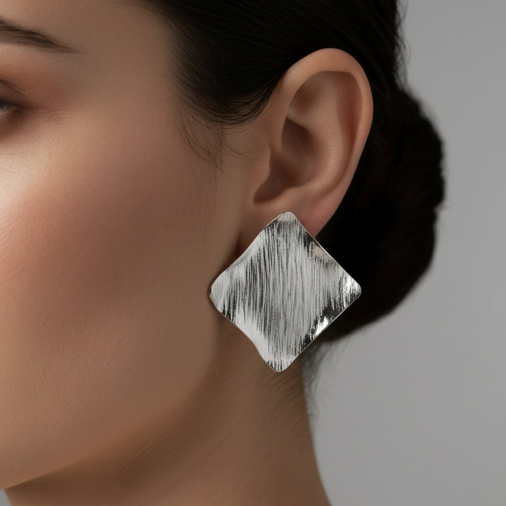 silver diamond-shaped earrings on a model