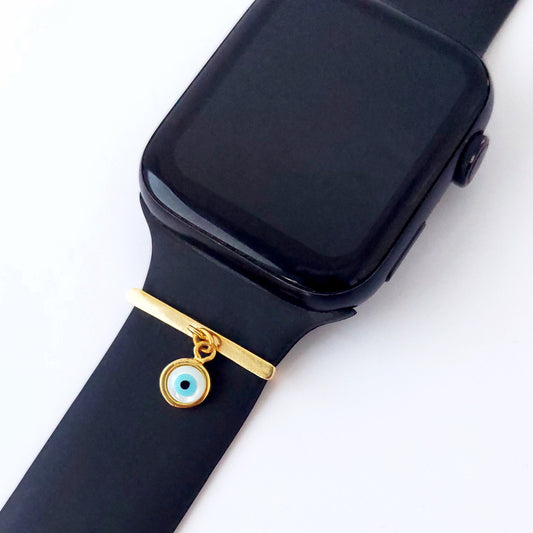 Black smartwatch with a gold charm and evil eye smart watch band add on on a white background