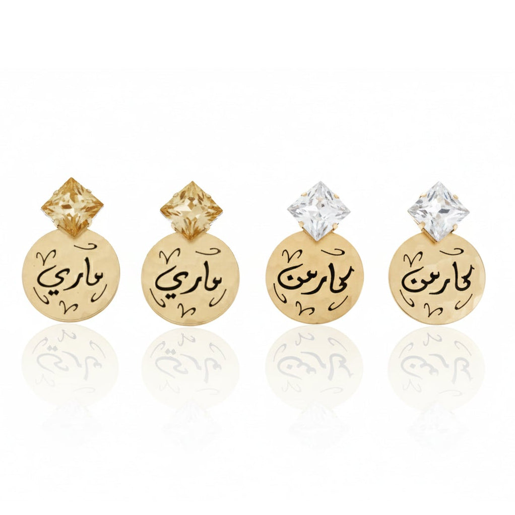 Pair of gold earrings with Arabic text on a white background