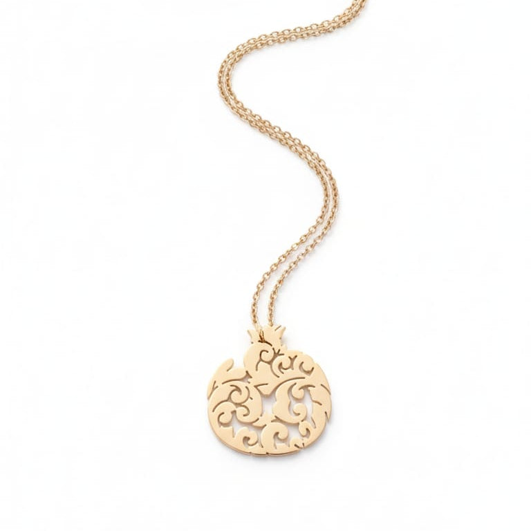 Gold necklace with a decorative pendant on a white background