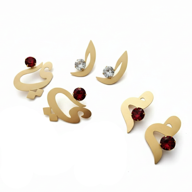 Gold earrings with red and clear gemstones on a white background