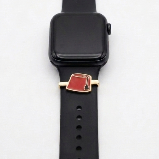 Black smartwatch with a red tarbouch gold plated band charm on a white background
