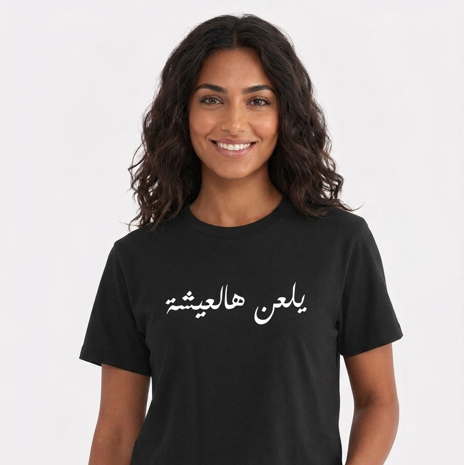 Woman wearing a black t-shirt with Arabic text on a white background