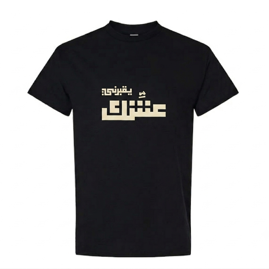 A black short-sleeve crewneck t-shirt featuring a stylized beige Arabic text graphic yo2borni 3eshik printed across the chest, displayed on a solid white background.